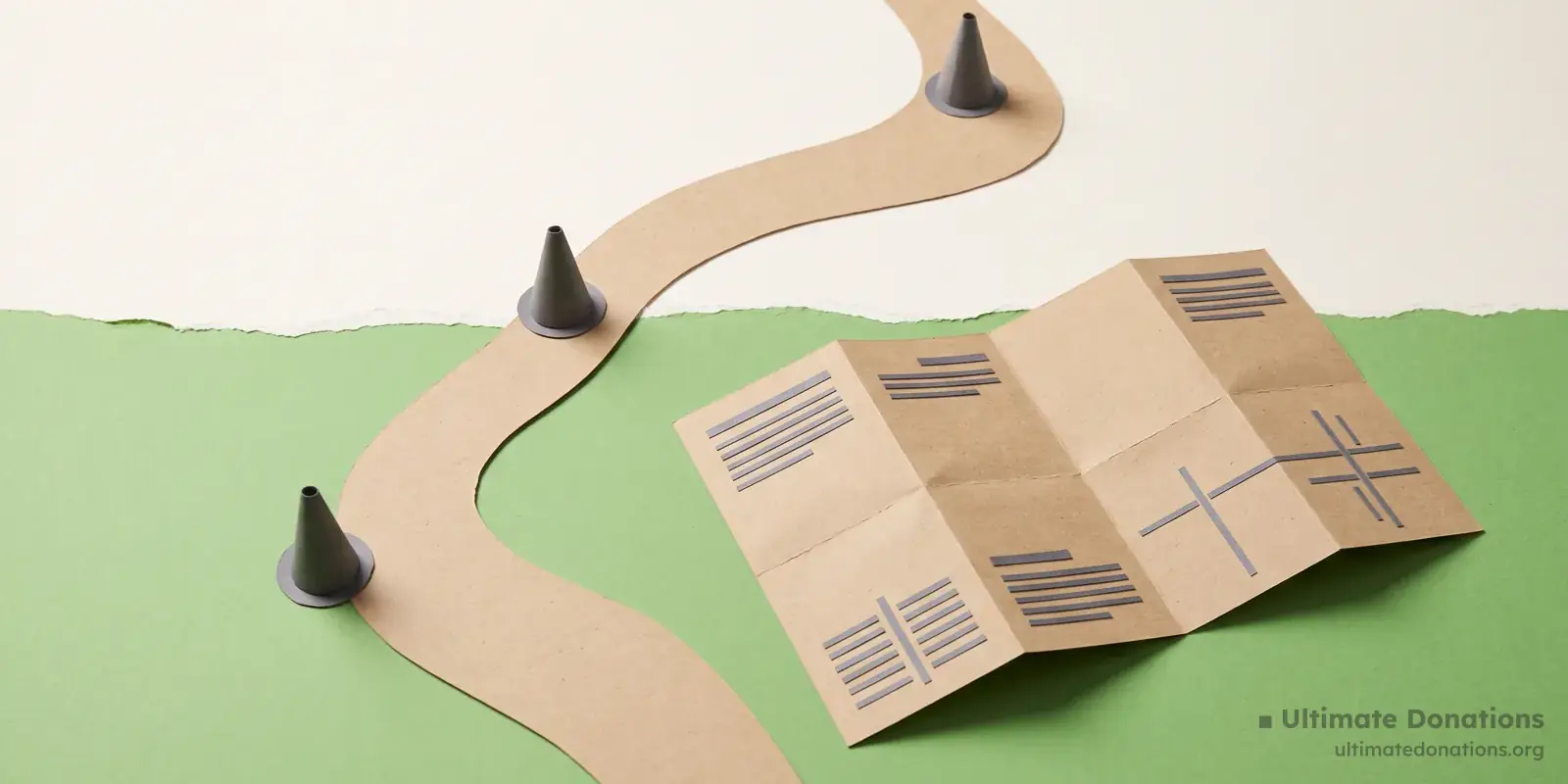 Cut-paper illustration: a winding paper path, three small cone markers, and a folded map.